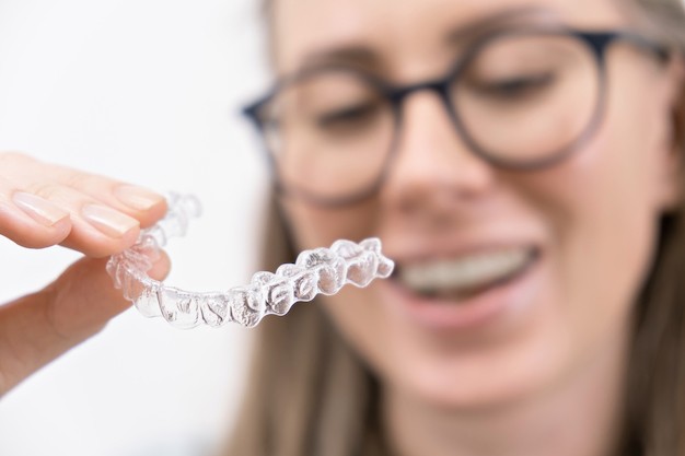 smiling woman using the best clear aligners