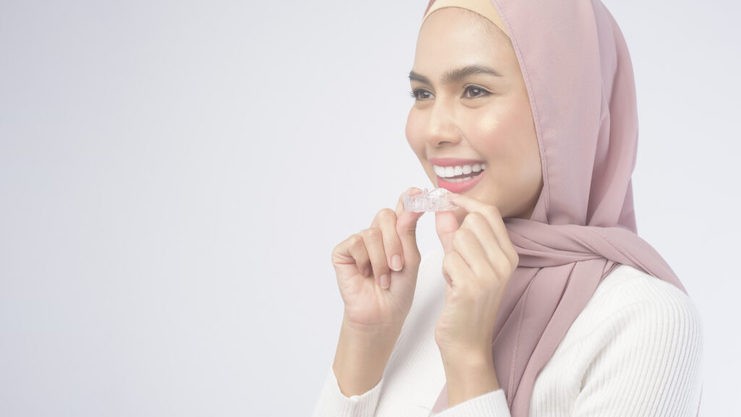 woman holding invisalign clear aligners