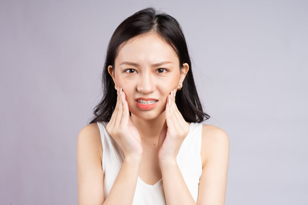 woman in pain because of emerging wisdom teeth