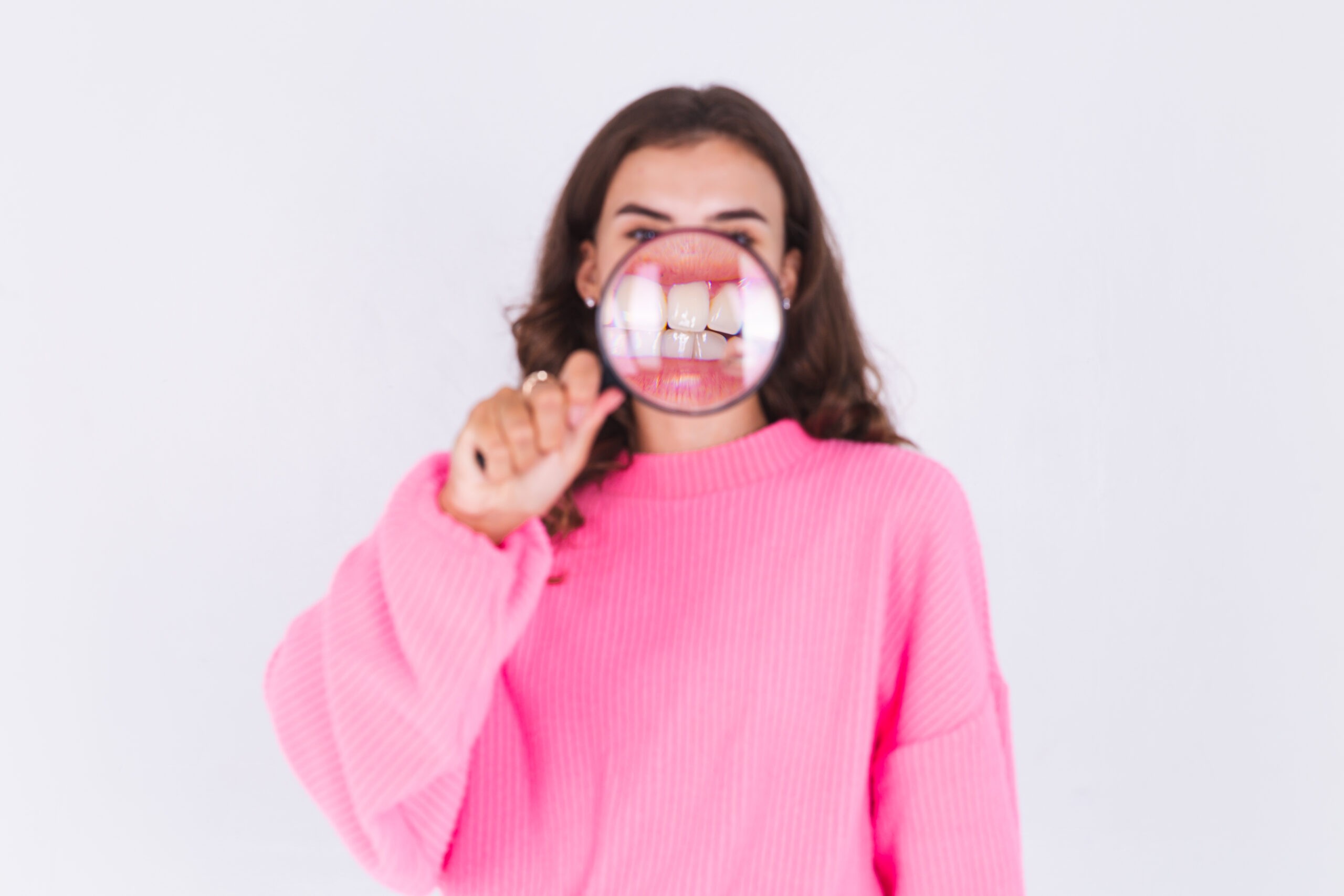person with a magnifier showing teeth